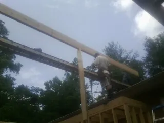 Carpenter setting a ridge beam over a new addition frame — Ice Dam Removal by Roofing Brothers in Manasquan