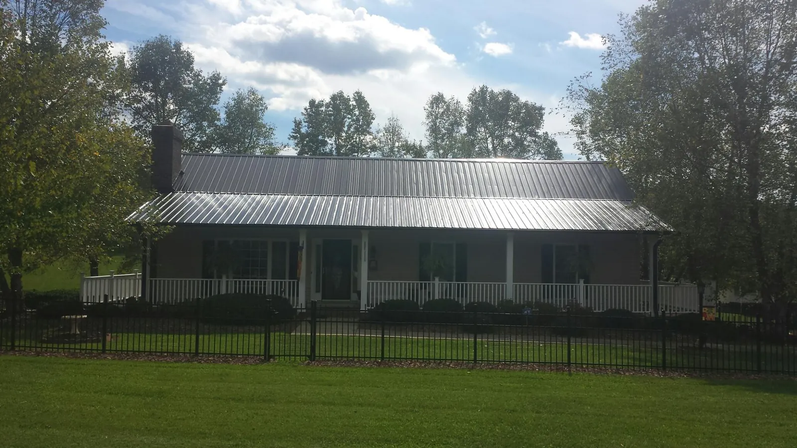 Gray metal roof on a brick ranch with a full width front porch — Gutter Guard Installation work by our crew in Manasquan
